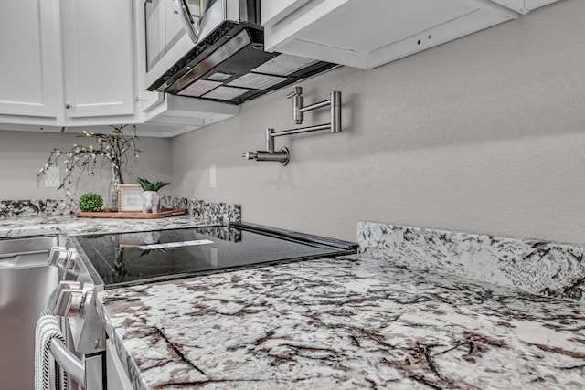 kitchen featuring stainless steel electric range and white cabinets