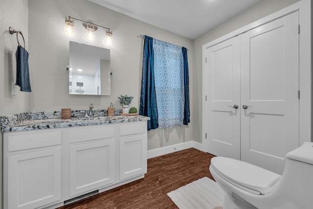 bathroom featuring hardwood / wood-style flooring, vanity, and toilet