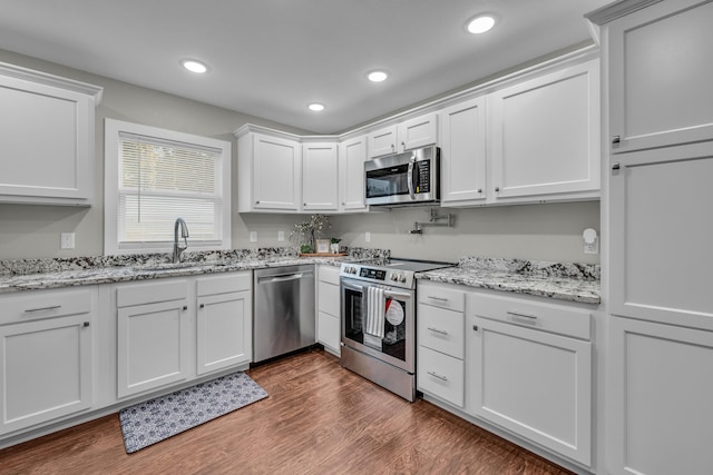 kitchen with white cabinetry, appliances with stainless steel finishes, sink, and dark hardwood / wood-style flooring