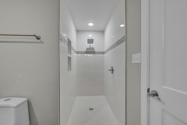 bathroom with toilet and a tile shower