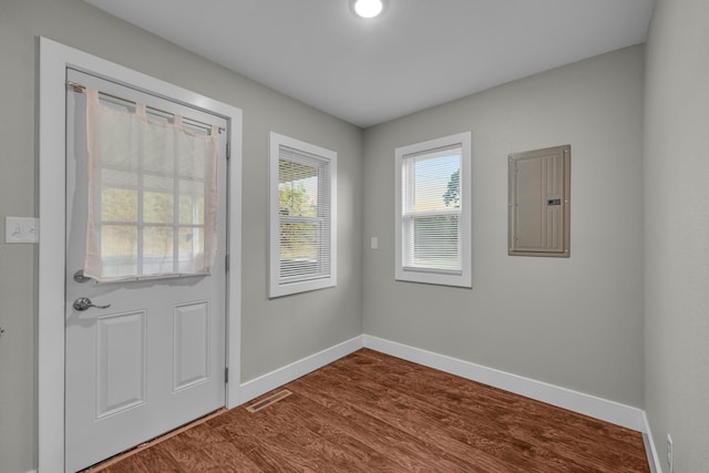 doorway to outside with hardwood / wood-style floors and electric panel