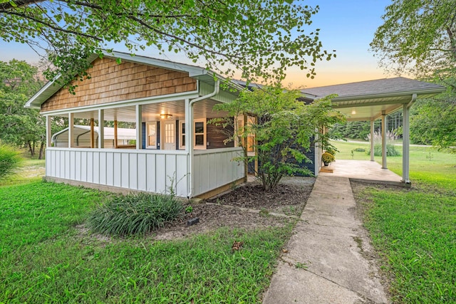 property exterior at dusk with a lawn