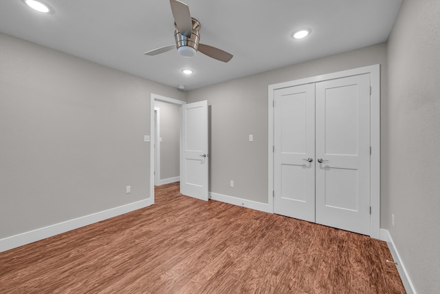 unfurnished bedroom with ceiling fan, a closet, and light hardwood / wood-style flooring