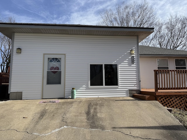 back of property featuring a wooden deck and a patio area