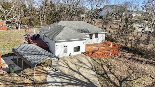 back of house featuring a deck and roof with shingles