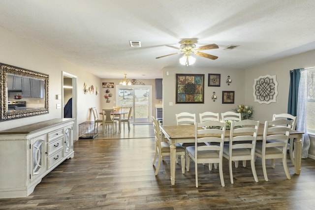 dining area with dark wood-style floors, ceiling fan, visible vents, and a textured ceiling