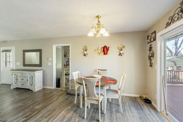 dining room featuring an inviting chandelier, baseboards, and wood finished floors