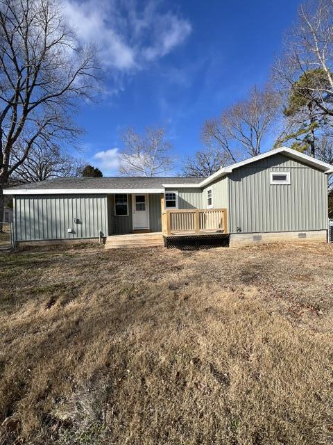 back of property featuring a yard and a deck