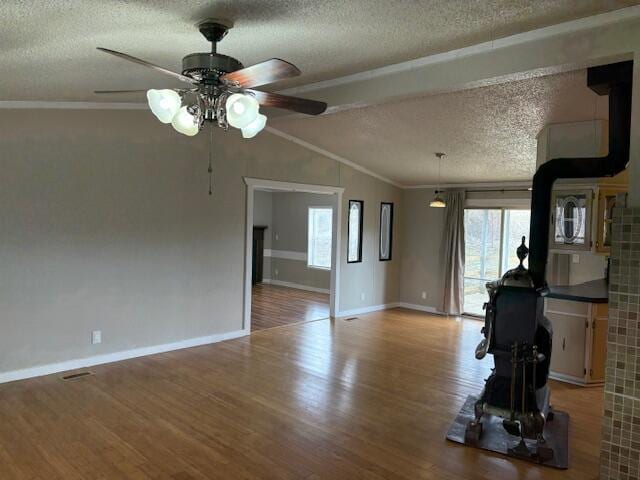 unfurnished living room featuring vaulted ceiling, plenty of natural light, hardwood / wood-style floors, and a textured ceiling