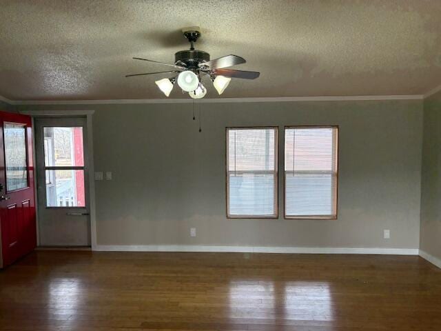 empty room featuring crown molding, dark wood-type flooring, and a textured ceiling