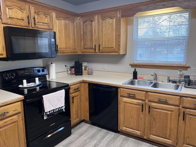 kitchen featuring sink, black appliances, and light hardwood / wood-style floors