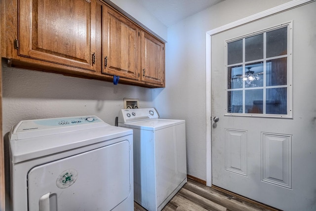 laundry area featuring hardwood / wood-style floors, cabinets, and washing machine and clothes dryer