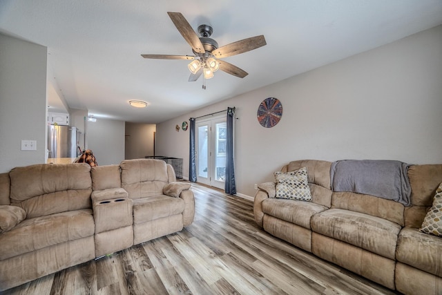 living room featuring ceiling fan and light hardwood / wood-style floors