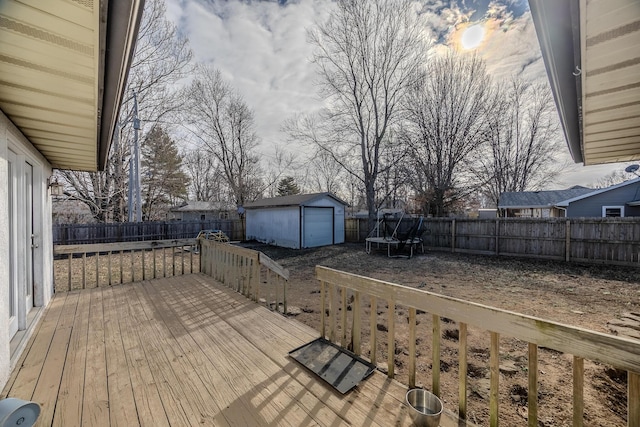 wooden deck featuring a storage shed and a trampoline