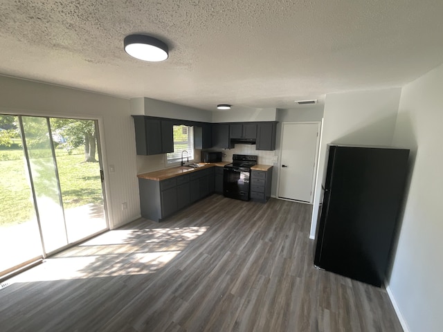 kitchen featuring sink, gray cabinetry, dark hardwood / wood-style floors, black appliances, and a textured ceiling