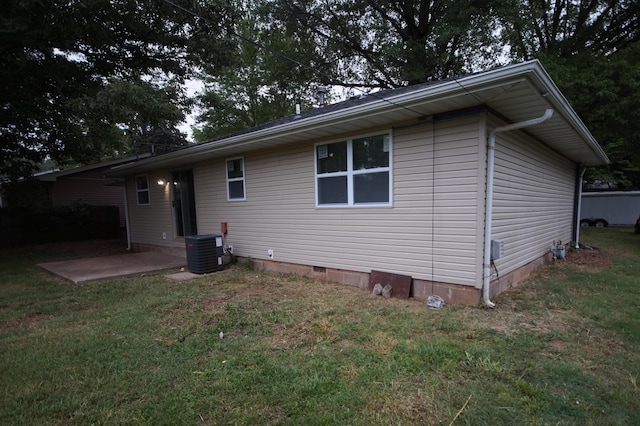 rear view of property with central AC unit, a yard, and a patio