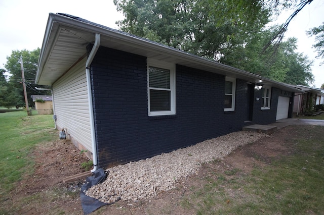 view of property exterior featuring a garage and a lawn