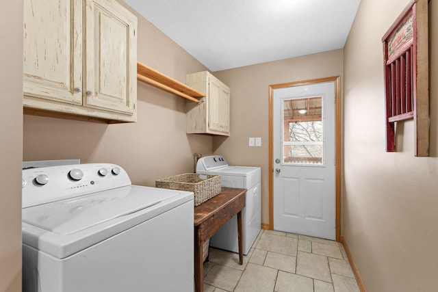 washroom with light tile patterned floors, washing machine and dryer, cabinet space, and baseboards