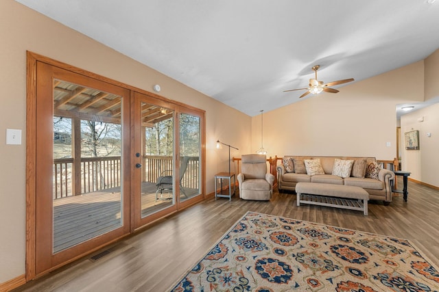 living area with baseboards, visible vents, vaulted ceiling, and dark wood finished floors