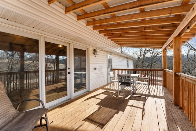 wooden deck featuring outdoor dining area and french doors