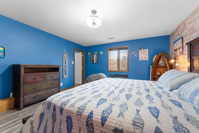 bedroom with light wood-style flooring and baseboards