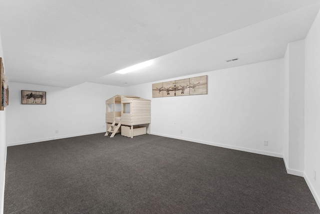 interior space featuring baseboards, visible vents, and dark colored carpet