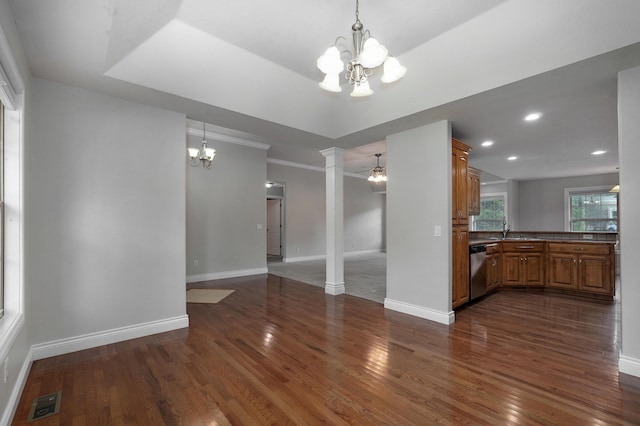 interior space with an inviting chandelier, dark wood-type flooring, sink, and ornate columns