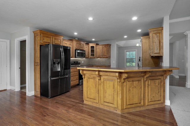 kitchen featuring backsplash, a kitchen breakfast bar, stainless steel appliances, dark hardwood / wood-style flooring, and kitchen peninsula