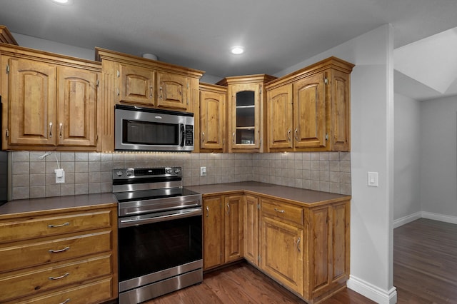 kitchen with stainless steel appliances, dark hardwood / wood-style floors, and decorative backsplash