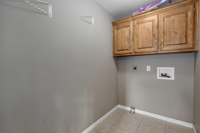 laundry room with light tile patterned floors, hookup for a washing machine, cabinets, a textured ceiling, and hookup for an electric dryer