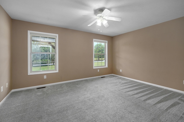 carpeted spare room featuring ceiling fan