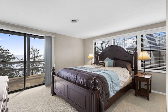 bedroom featuring light colored carpet and multiple windows