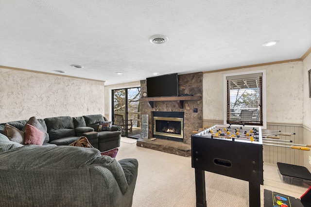 carpeted living room featuring crown molding, a healthy amount of sunlight, a textured ceiling, and a fireplace