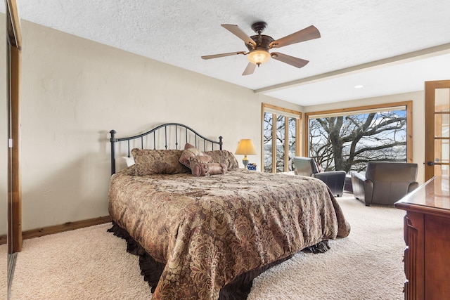 carpeted bedroom with ceiling fan and a textured ceiling