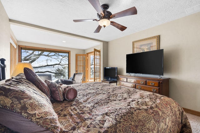 bedroom featuring ceiling fan, carpet, a textured ceiling, and french doors