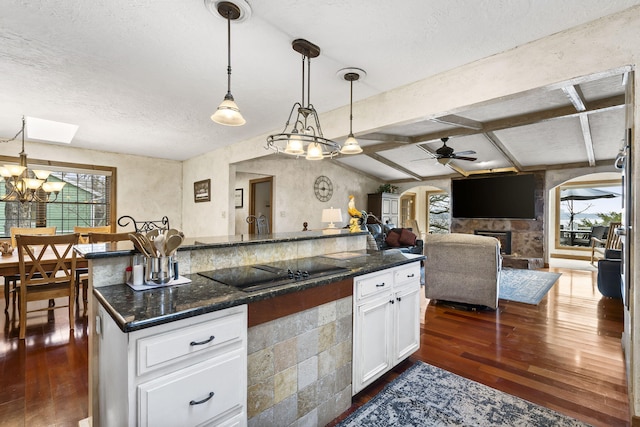 kitchen featuring dark hardwood / wood-style floors, white cabinets, hanging light fixtures, black electric stovetop, and plenty of natural light