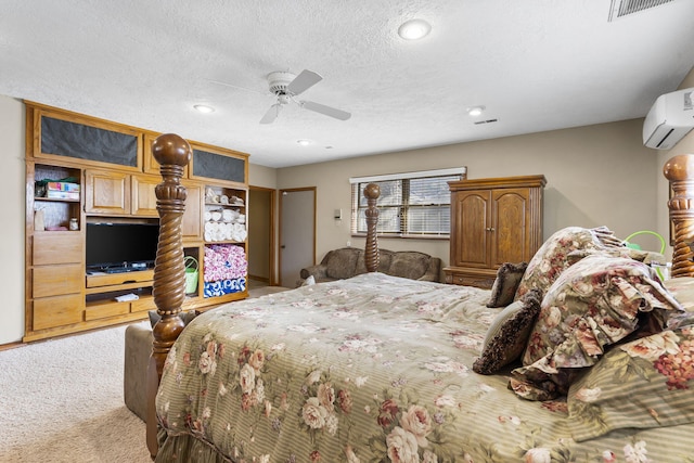 bedroom featuring light colored carpet, a wall unit AC, ceiling fan, and a textured ceiling