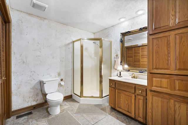 bathroom featuring toilet, vanity, and a shower with shower door