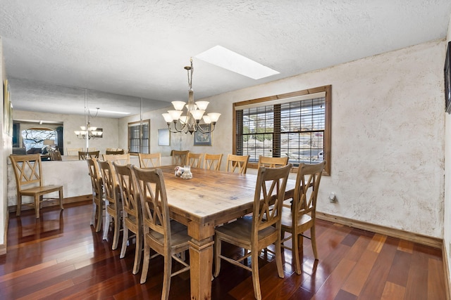 dining room with dark hardwood / wood-style floors, a notable chandelier, and a textured ceiling