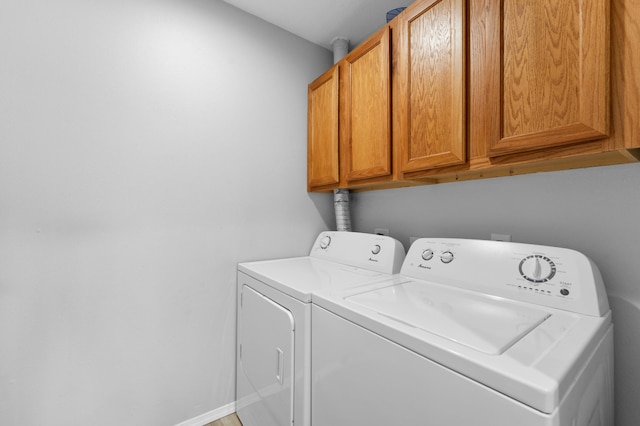 laundry area featuring cabinets and washing machine and clothes dryer