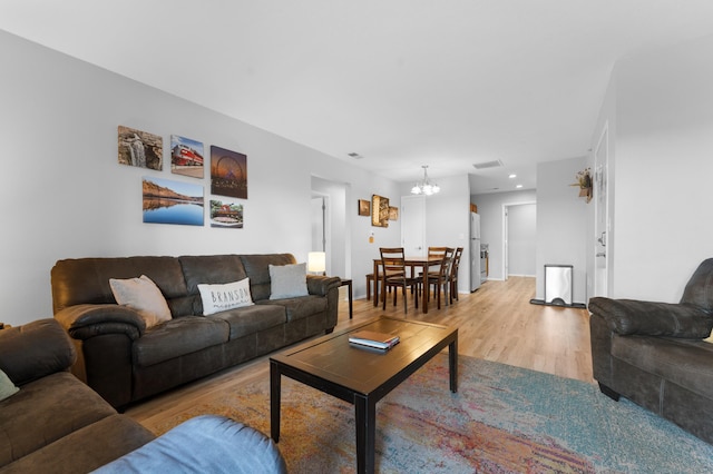 living room with a notable chandelier and light hardwood / wood-style floors