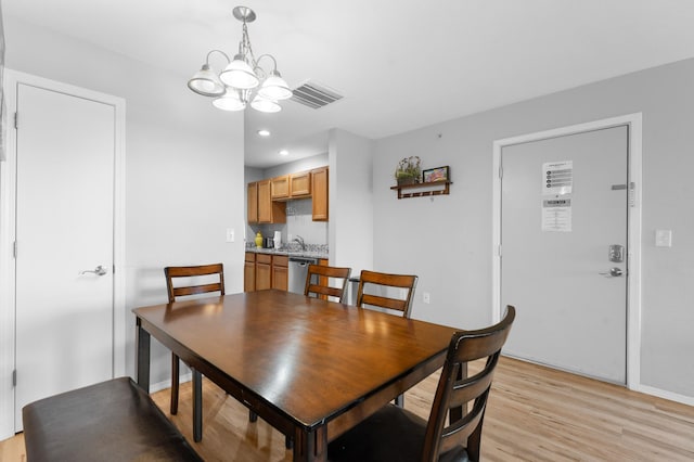 dining space with a notable chandelier and light wood-type flooring