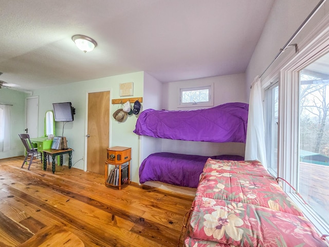 bedroom featuring wood-type flooring and access to exterior