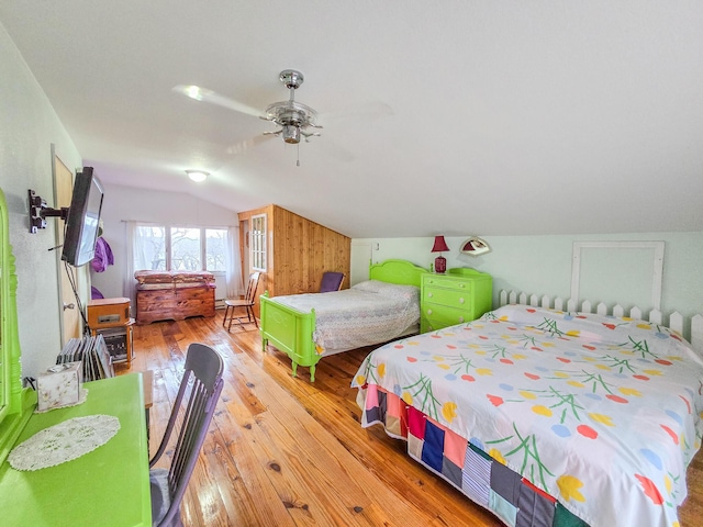 bedroom with ceiling fan, lofted ceiling, and light wood-type flooring