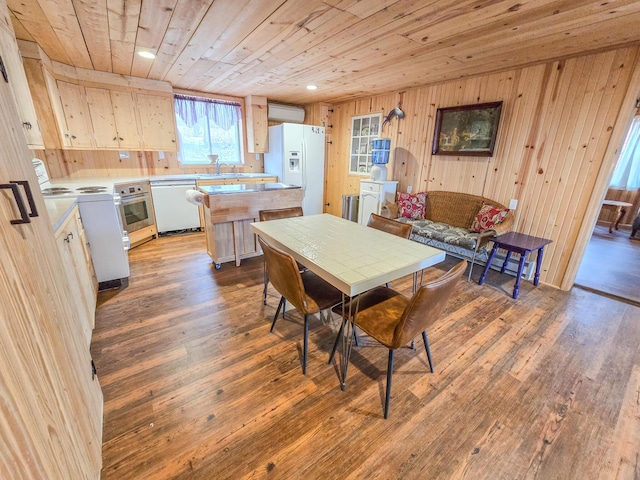 dining room with wood ceiling, sink, hardwood / wood-style floors, and wood walls