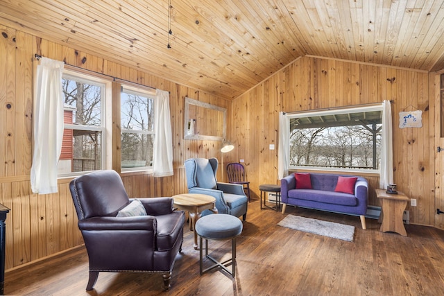 sitting room with hardwood / wood-style floors, a wealth of natural light, wooden walls, and vaulted ceiling