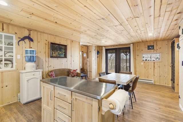 kitchen featuring a baseboard heating unit, hardwood / wood-style floors, french doors, and a center island