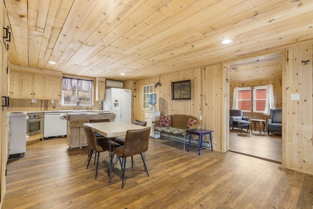 dining room with dark hardwood / wood-style flooring, sink, wood ceiling, and wood walls