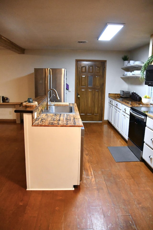 kitchen featuring electric stove, sink, stainless steel fridge, dark hardwood / wood-style floors, and white cabinets