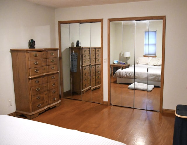 bedroom featuring multiple closets and hardwood / wood-style flooring